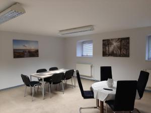 a meeting room with tables and chairs and a whiteboard at Monteurwohnung Zentrum in Zerbst