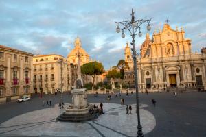 a city square with a fountain in front of a building at Le Suites Del Duomo House in Catania