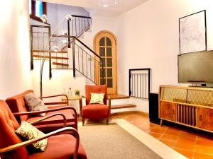 a living room with two chairs and a flat screen tv at Casa Eugenia in Argegno