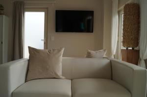 un divano bianco con 2 cuscini in soggiorno di Haus am See a Storkow