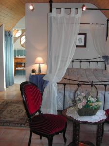 a bedroom with a bed with a table and chairs at Le Domaine de Rugornou Vras in Brasparts