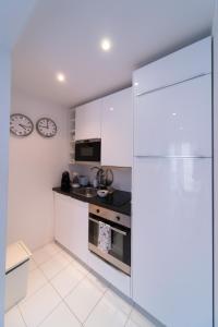 a kitchen with white cabinets and a refrigerator at Bliss Lisbon Apartments - Bairro Alto in Lisbon