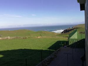 a view of a green field with the ocean at Apartamentos Santa Justa in Ubiarco