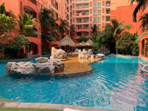 ein Pool in einem Resort mit Felsen im Wasser in der Unterkunft Seven Seas Condo Resort Jomtien in Jomtien Beach