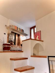 a living room with a stone fireplace and a window at Casa Eugenia in Argegno