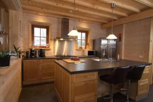 uma cozinha com armários de madeira e um balcão preto em Houten villa Albert em Den Ham