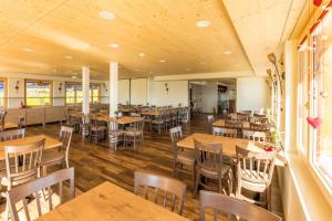 un restaurante vacío con mesas y sillas de madera en Berghotel Schonhalden, en Flums