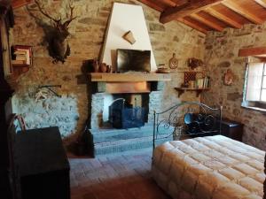 a bedroom with a fireplace in a stone wall at Vignoli in Bagni di Lucca