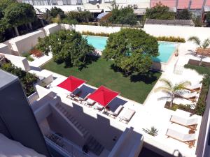 an aerial view of a swimming pool with red umbrellas at Casa René - Charming apartments in Almada