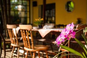 ウバトゥバにあるBeira Marのテーブル(椅子付)と紫の花のテーブル