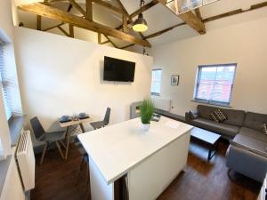 ein Wohnzimmer mit einem Sofa und einem Tisch in der Unterkunft Loft at The Coach House Apartments in Leeds