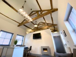 ein Wohnzimmer mit einem Kamin und einem TV an der Wand in der Unterkunft Loft at The Coach House Apartments in Leeds