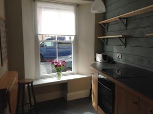a kitchen with a vase of flowers sitting on a window sill at 6 Hill Street, Haverfordwest. in Pembrokeshire