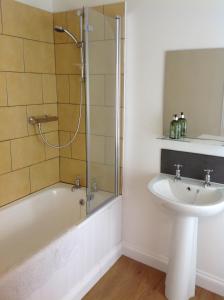 a bathroom with a tub and a sink and a shower at 6 Hill Street, Haverfordwest. in Pembrokeshire