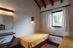 een kleine slaapkamer met een bed en een raam bij Pedras Del Rei I in Tavira