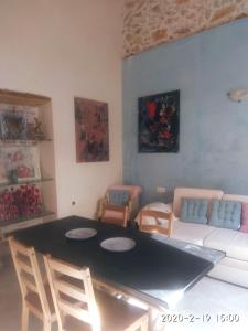 Una sala de estar con una mesa y sillas y un sofá. en Spartis House 50m from the beach, en La Canea