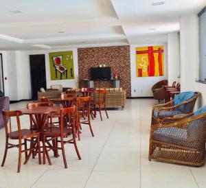 uma sala de jantar com mesas e cadeiras de madeira em Hotel Algas Marinhas em Aracaju