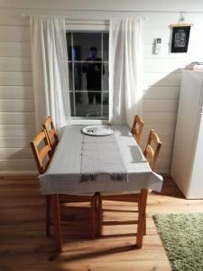 a table and chairs in a room with a window at Villa Kunkku in Kuivakangas