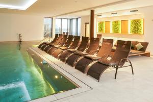 a swimming pool with chairs next to a swimming pool at Schloss Döttingen in Braunsbach