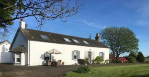 a white house with a black roof at South Doll Farm Cottage in Airth