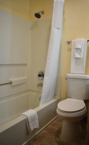 a bathroom with a white toilet and a bath tub at SureStay Hotel by Best Western Portland City Center in Portland