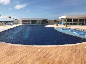 una gran piscina con sillas y un edificio en Golden lake Residence Bl3 110, en Arraial do Cabo