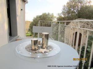 een bord met twee kaarsen op een tafel op een balkon bij Mare Apartment 4 in Scalea