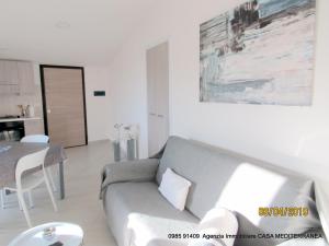 Sala de estar con sofá gris y mesa en Mare Apartment 4, en Scalea