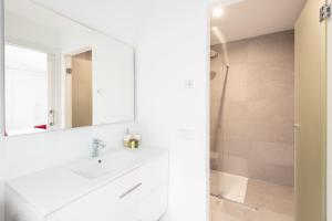 a white bathroom with a sink and a mirror at Cituspace Arturo Soria in Madrid