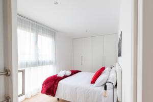 Cituspace Arturo Soria في مدريد: غرفة نوم بسرير ومخدات حمراء وبيضاء
