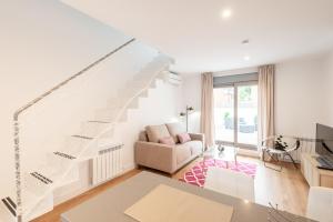 una sala de estar blanca con una escalera blanca en Cituspace Arturo Soria en Madrid