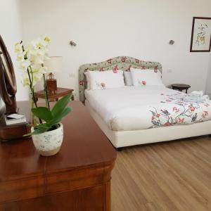 um quarto com uma cama e uma mesa com um vaso de flores em DE PIANTE GUEST em Busto Arsizio