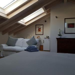 sypialnia z białym łóżkiem i kanapą w obiekcie DE PIANTE GUEST w mieście Busto Arsizio
