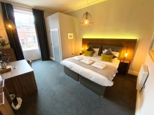 a hotel room with a large bed with yellow pillows at The Waterhouse at Claremont Apartments in Leeds