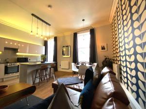 a living room with a couch and a kitchen at The Waterhouse at Claremont Apartments in Leeds