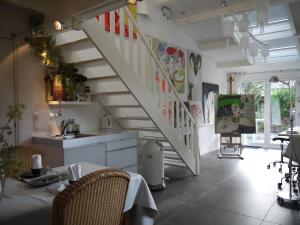 una cocina con una escalera con mesa y sillas en Bed and Breakfast Valckenbosch, en Zeist