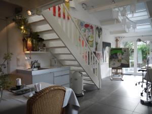 a kitchen with a staircase with a table and chairs at Bed and Breakfast Valckenbosch in Zeist