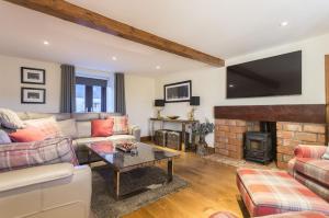 uma sala de estar com um sofá e uma lareira em Lallybroch em Cambusbarron