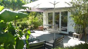 a patio with an umbrella and a table and chairs at Bed and Breakfast Valckenbosch in Zeist