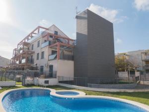 a building with a swimming pool in front of a building at Apartamentos Atenea Playa Romana in Alcossebre