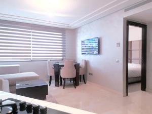 a room with a table and chairs and a bed at MAARIF LUXURY APART -Urban Massira IV- in Casablanca