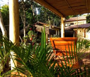 a porch with a christmas tree and a wooden chair at 4 Elementos Guest House in Arraial d'Ajuda