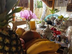 a table with a bunch of bananas and fruit on it at 4 Elementos Guest House in Arraial d'Ajuda