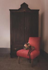 a red chair with a bouquet of flowers on it at Casa Minotti Relais in Gubbio