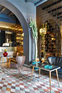 un vestíbulo con sillas, mesas y una pared de ladrillo en G-Rough, Rome, a Member of Design Hotels, en Roma