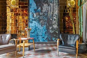 a room with two chairs and a table and a wall at G-Rough, Rome, a Member of Design Hotels in Rome