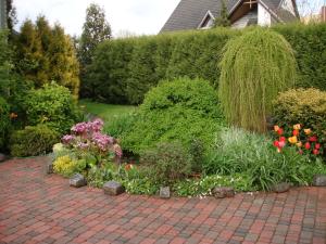 a garden with flowers and plants on a brick path at Cozy House Mētriņi in Ķekava