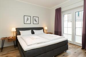 a bedroom with a large bed with white sheets at Fehmarn Mein Urlaub in Fehmarn