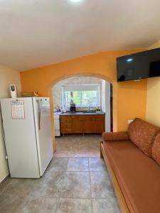 ein Wohnzimmer mit einem weißen Kühlschrank und eine Küche in der Unterkunft RINCÓN SERENO... Un lugar para disfrutar.... in Villa General Belgrano