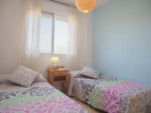a bedroom with two beds next to a window at Apartamentos Doña Maria in Alcossebre
